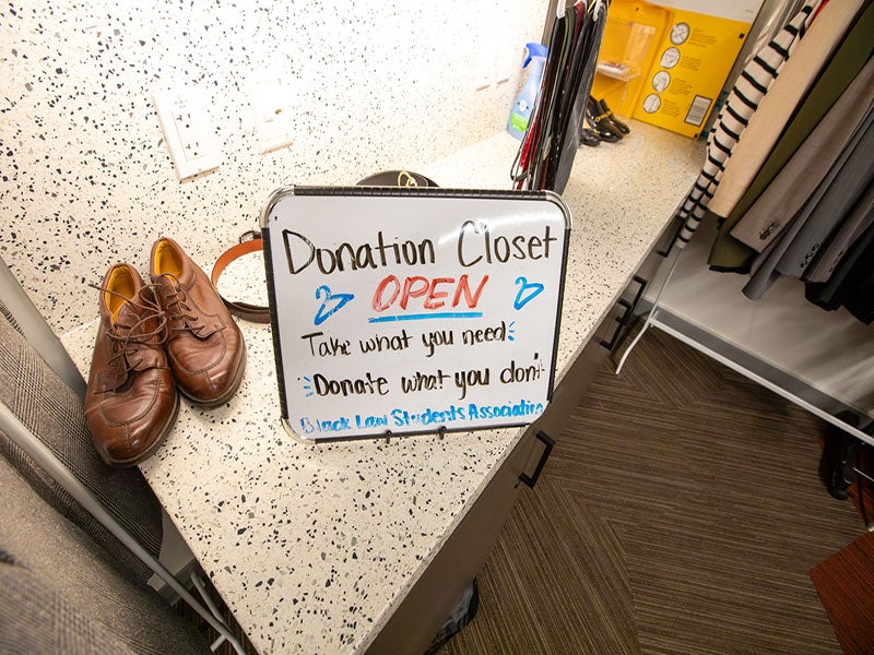 A white sign next to some brown shoes.